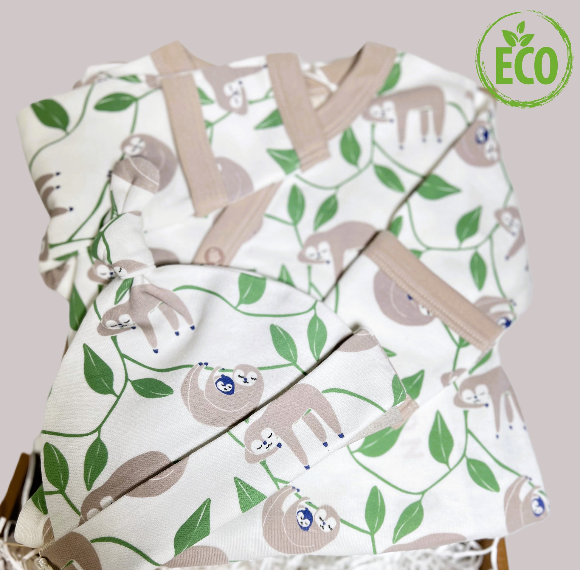 Organic cotton baby sleepsuit and hat with sloth print.