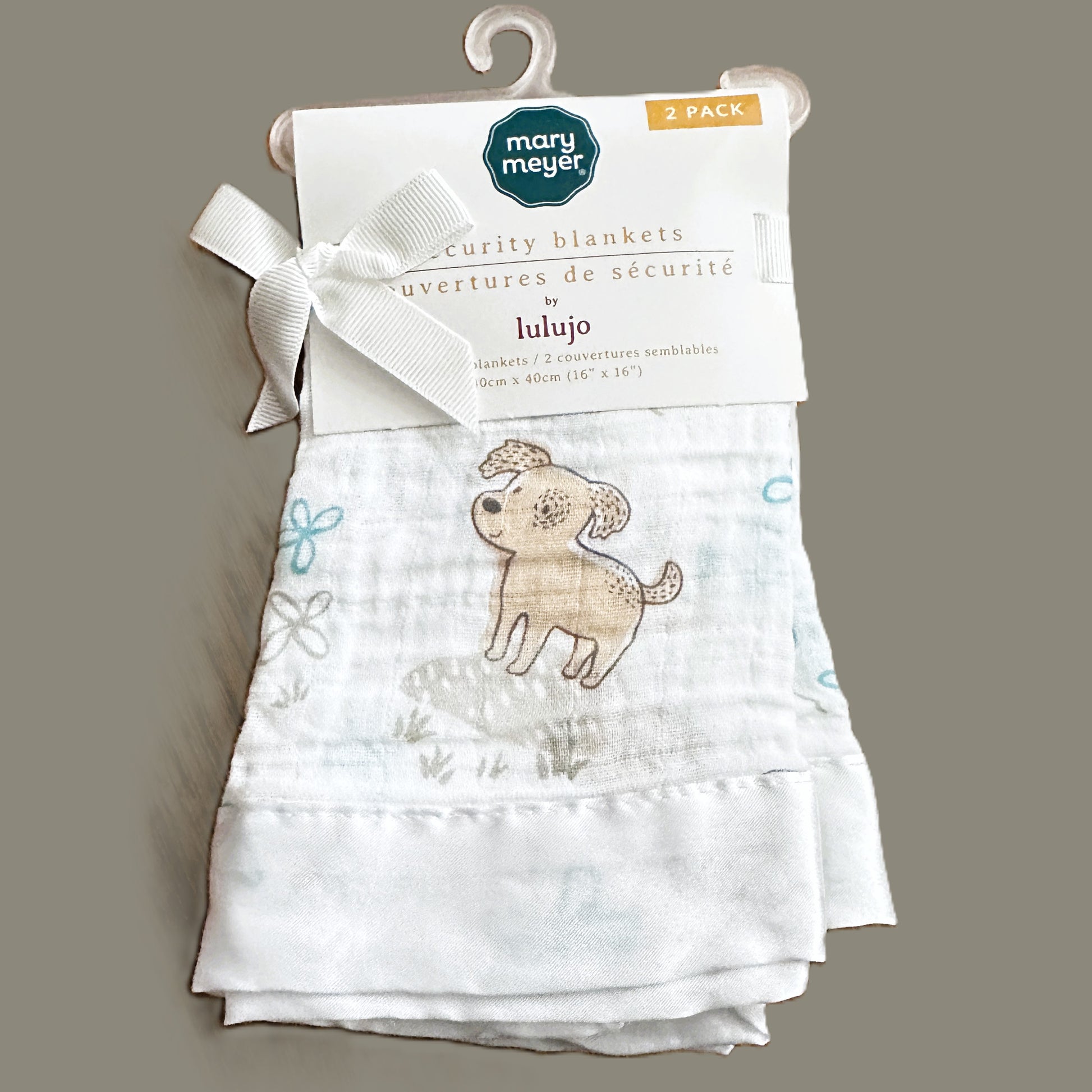 Two baby security blankets with a dog design on a hanger against a gray background, featuring the Mary Meyer brand.