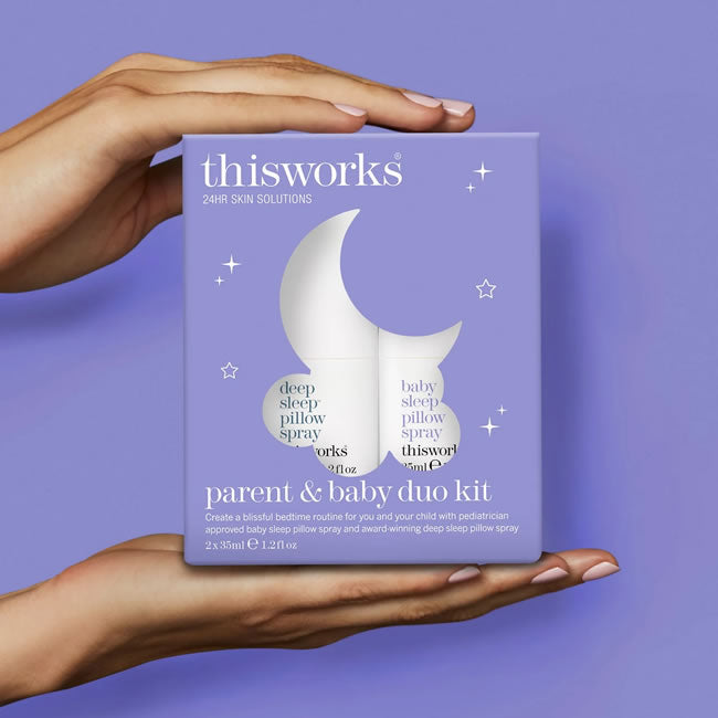 Hand holding a 'thisworks' parent and baby duo kit packaging against a purple background