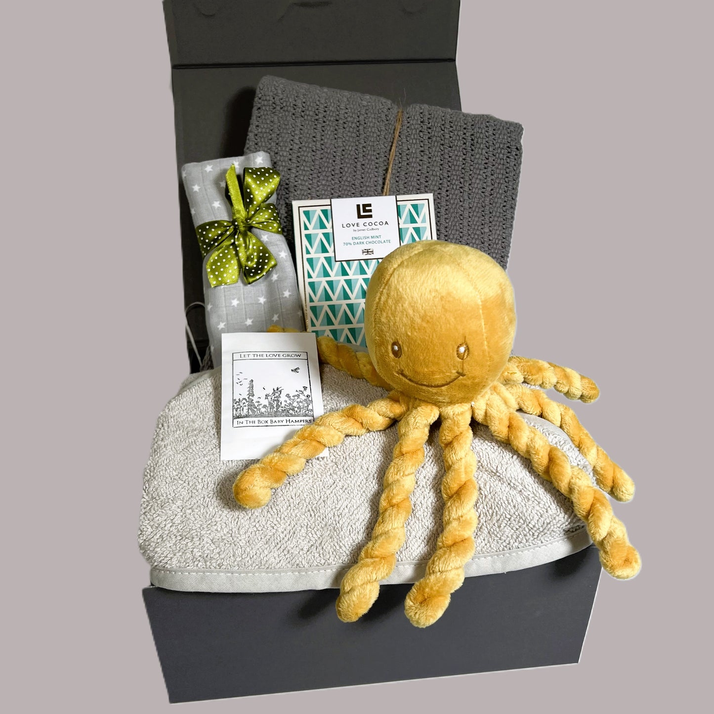 Neutral newborn baby gift hamper containing a Puipui octopus soft baby toy, a cotton cellular baby blanket, a grey cotton hooded baby towel, a bar of Love Cocoa chocolate and a grey muslin square.