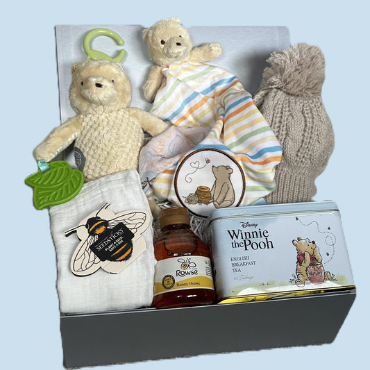 Winnie the pooh themed new baby gift hamper with toys, tea and honey