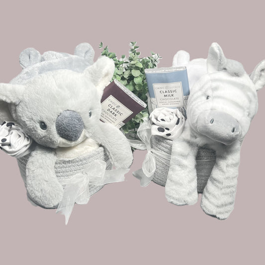 Unisex grey and white new baby hamper gifts in a cotton rope storage caddy in grey tied with a white organza ribbon, a grey and white koala bear or Zebra baby soft toy a bar of chocolate , a grey or white dressing gown and a black and white baby muslin.