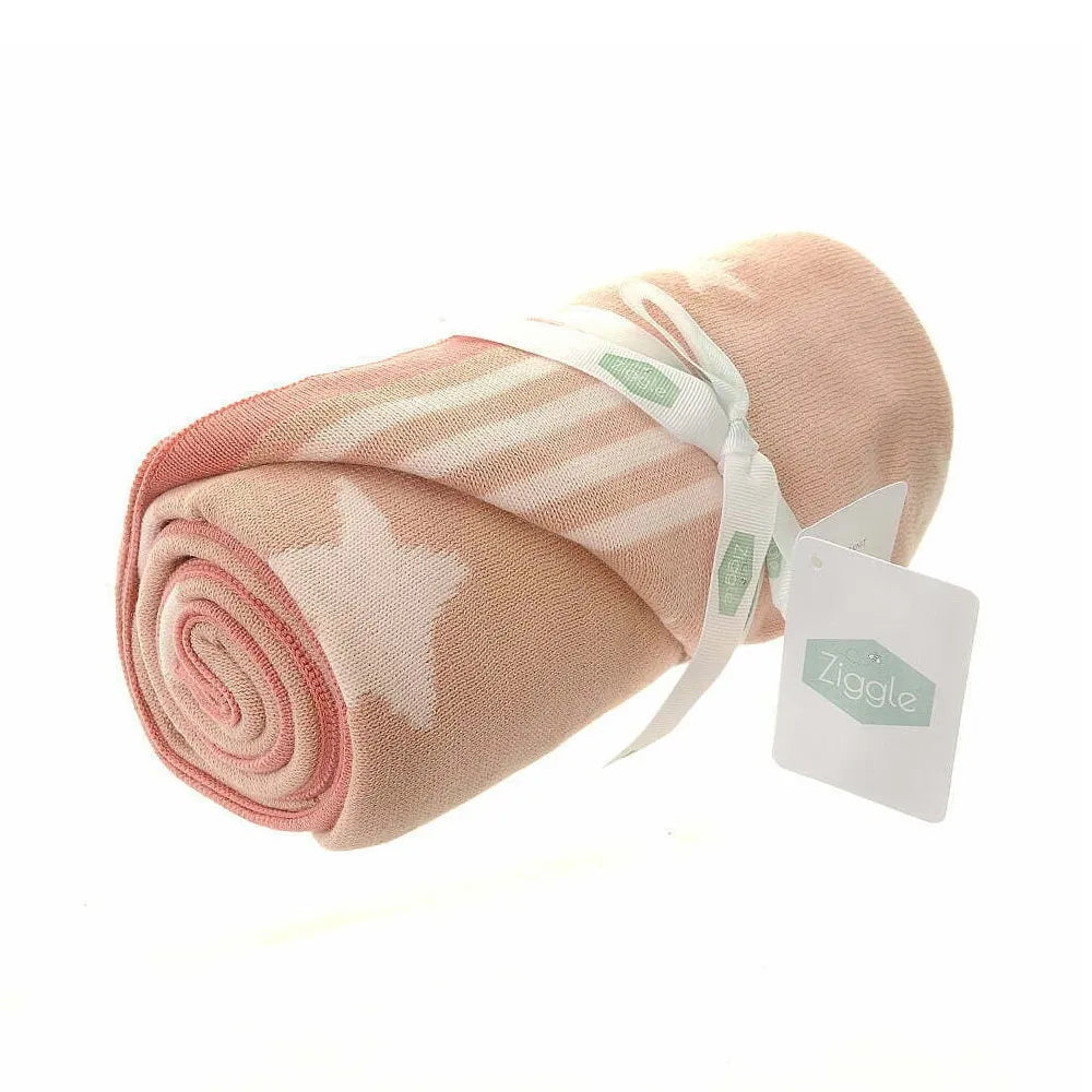 Rolled-up pink baby blanket with a tag on a white background
