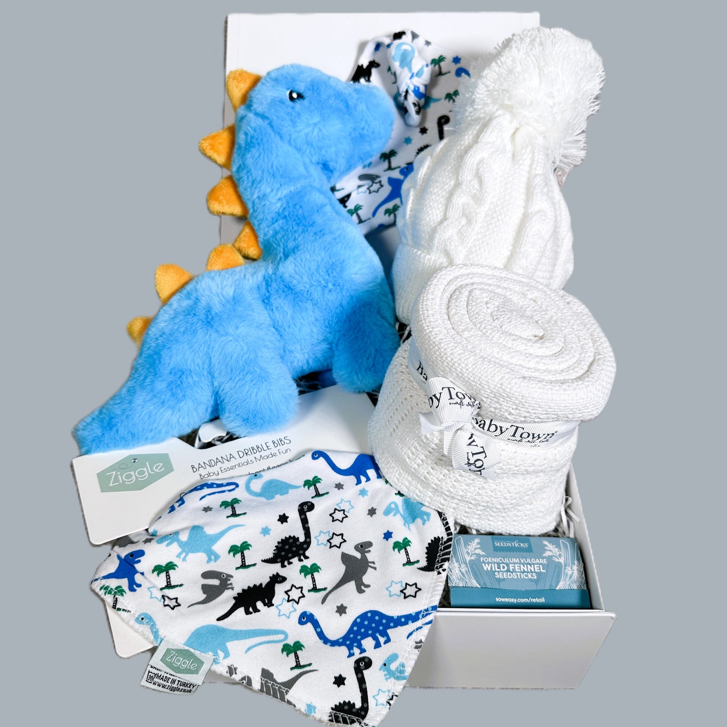 Blue dinosaur new baby hamper with dinosaur toy, baby blanket, dribble bib and baby knotty hat with dinosaur print.