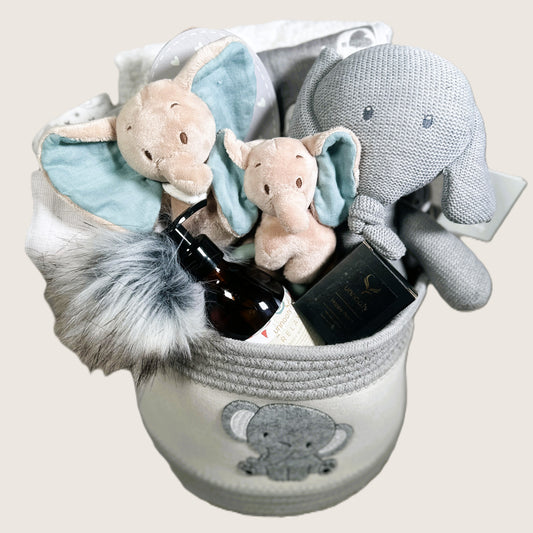 Baby gift basket with plush toys and baby care items on a beige background