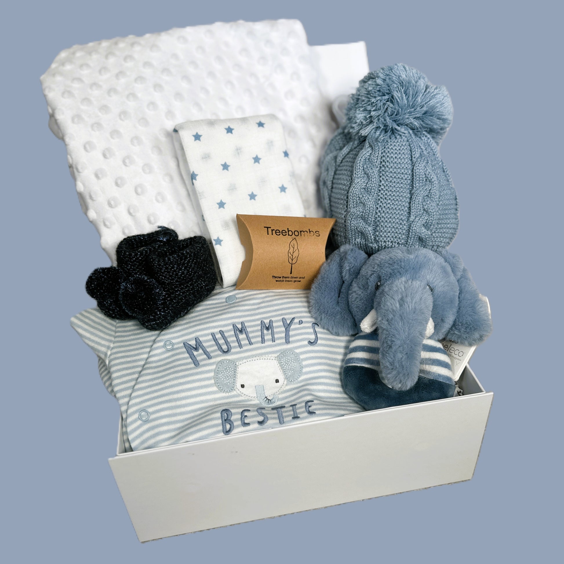 Baby gift set with clothing, blanket, and toys in a box on a light blue background