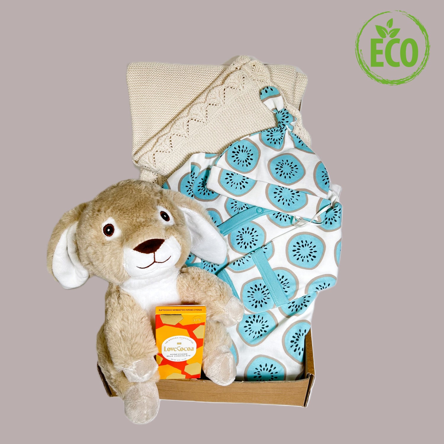 rganic cootin baby sleepssuit and matching knot hat with a blue kiwi print, a bunny soft baby toy, a bar of Love Cocoa chocolate and a fine cotton baby blanket in taupe