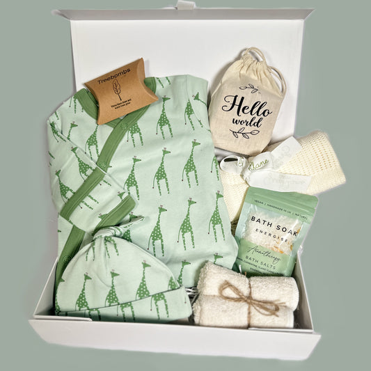 Green giraffe print baby grow and matching hat and bamboo cellular baby blanket in the new baby hamper gift.