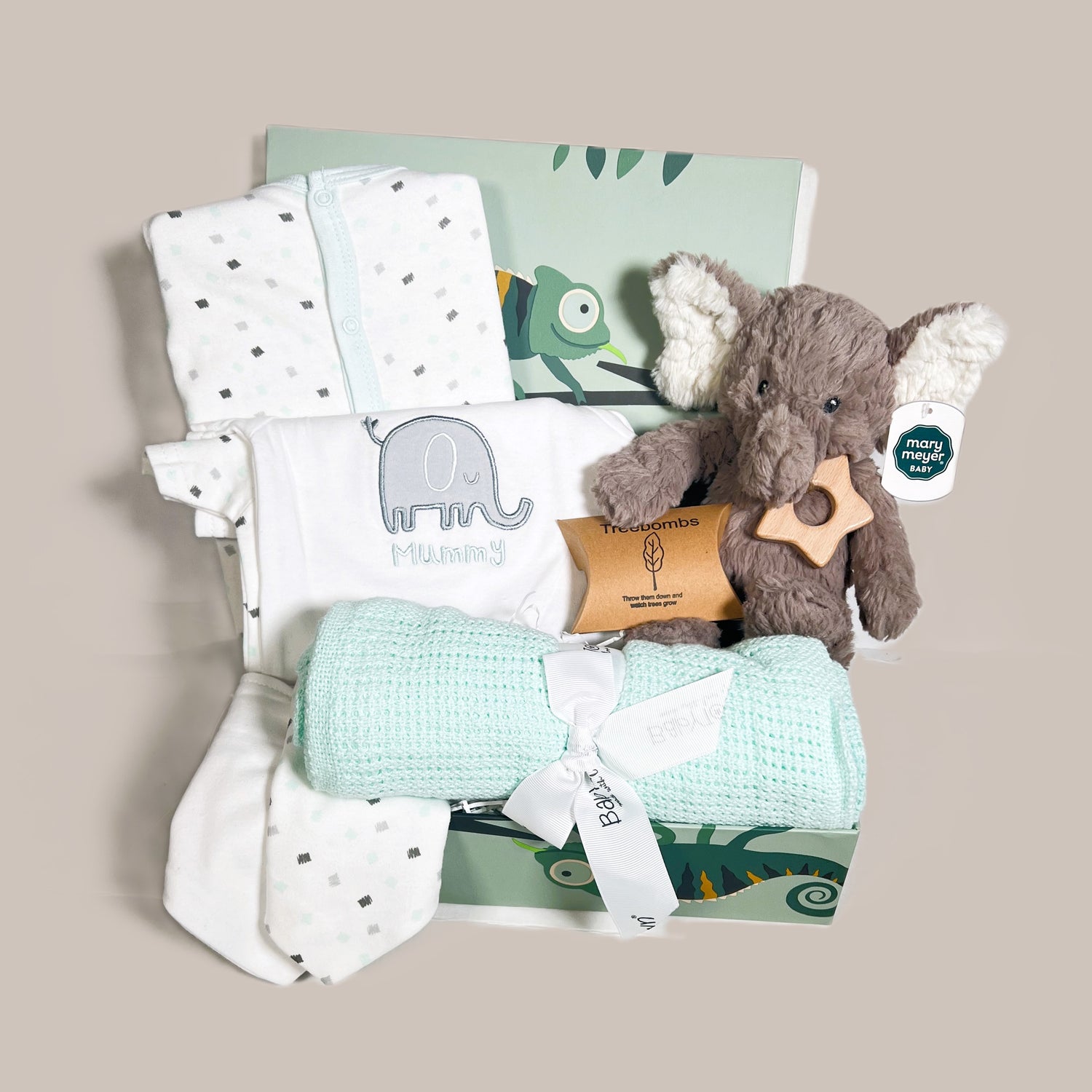 A neutral new baby hamper with a white and mint green baby layette set with an elephant motif, a Mary Meyer putty nursery elephant soft baby toy, a mint cellular cotton blanket, a Bambino star baby teether and a handmade baby keepsake box with chameleon print.