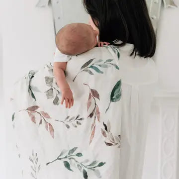 Baby a lseep draped in a bamboo and cotton swaddle blanket