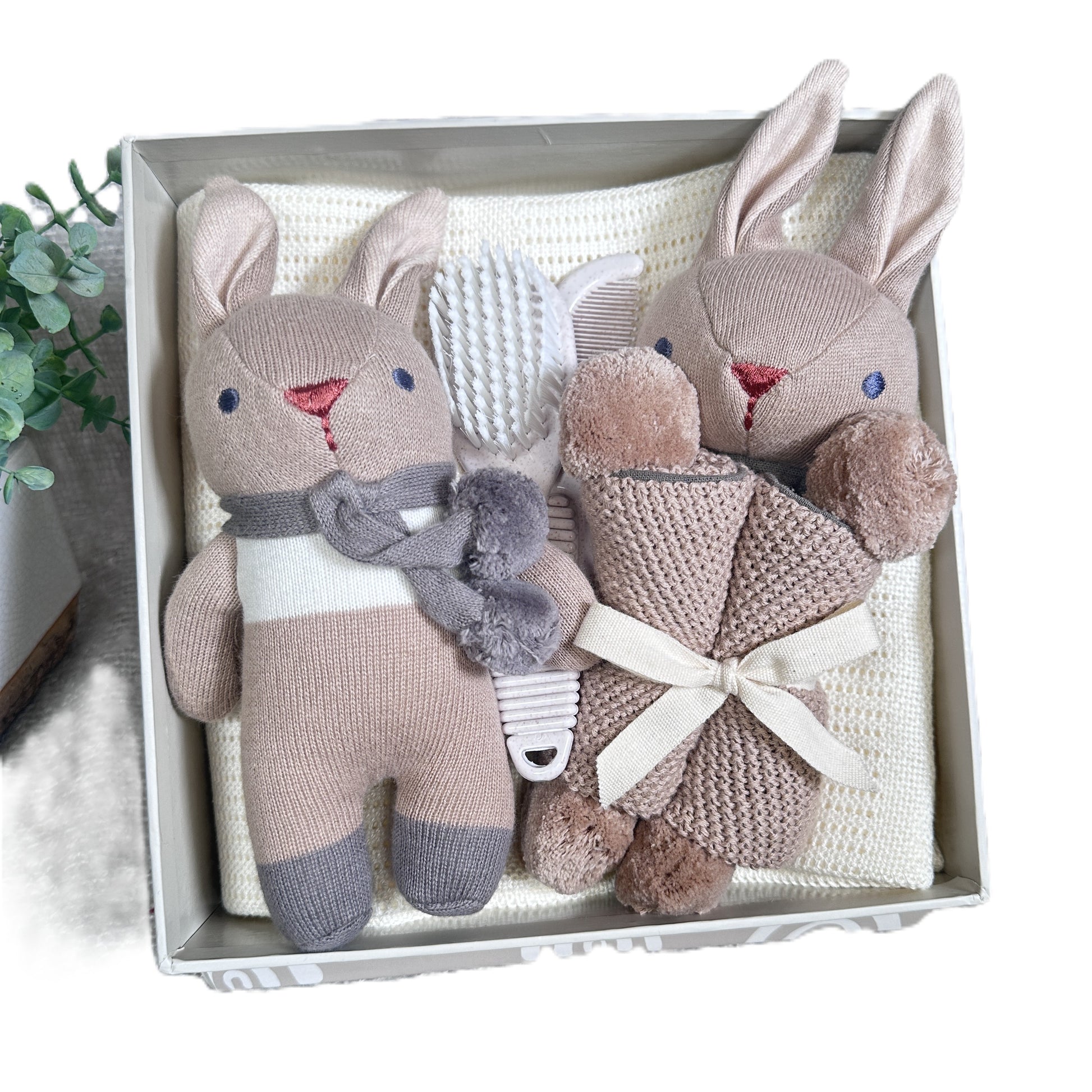 baby hamper with two rabbit baby toys and a blanket