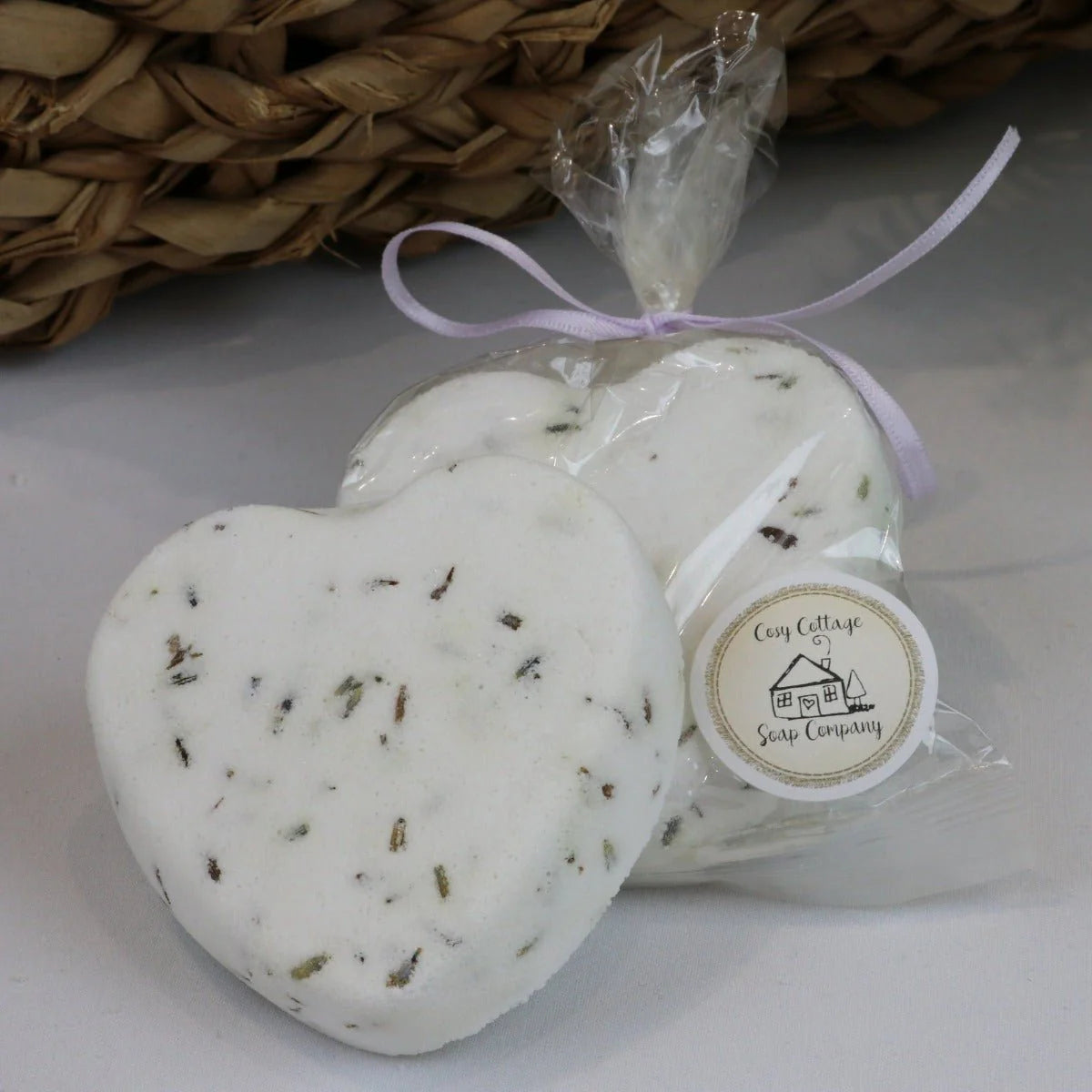 Heart-shaped bath bombs with a visible label on a white surface