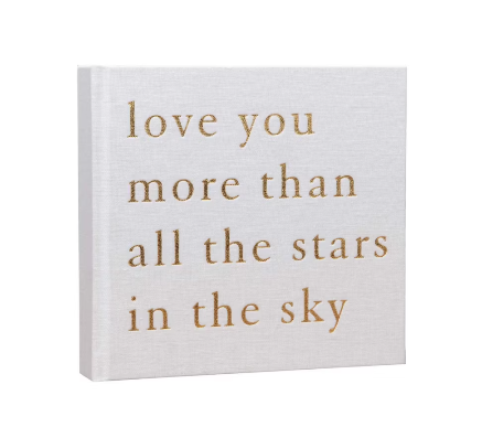 White linen baby photo album with gold text 'love you more than all the stars in the sky' on a white background
