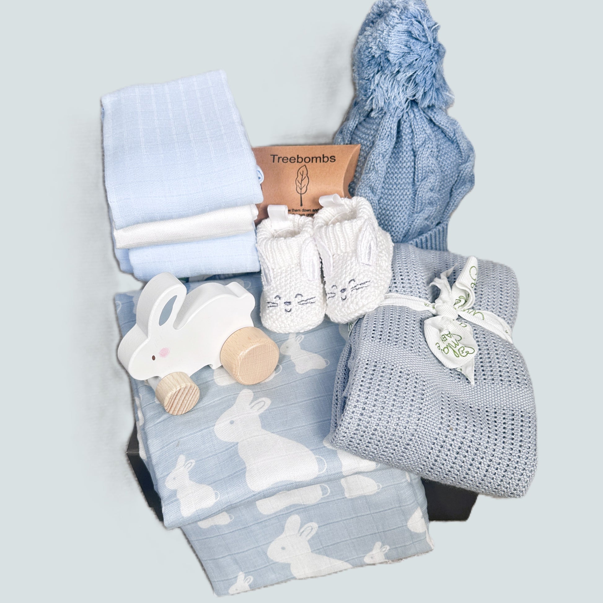 New baby hamper with blue baby blankets, baby hat and wooden toy