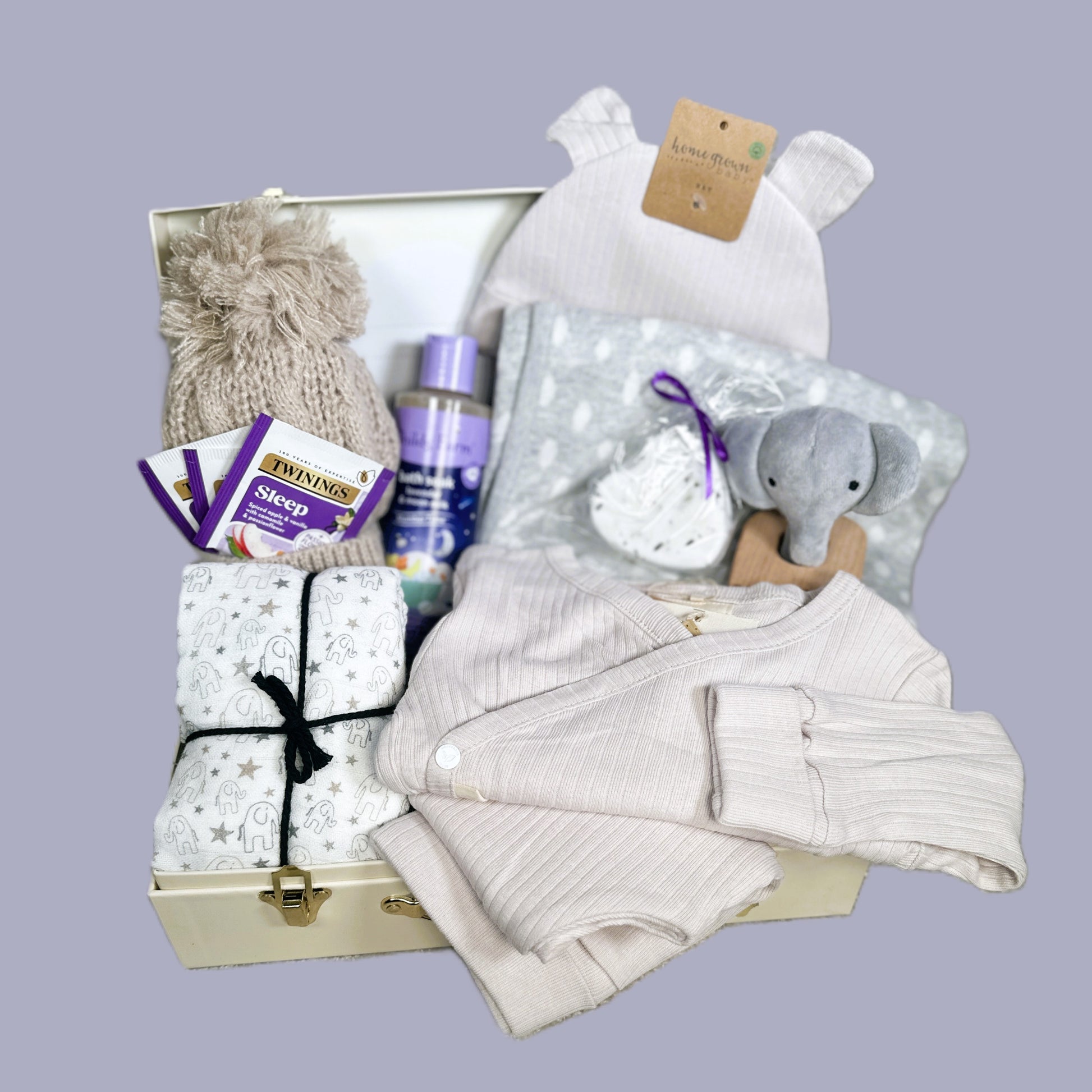 Baby gift basket with clothes, toys, and items on a gray background