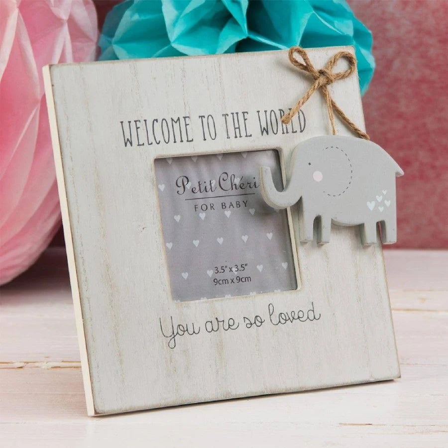 Wooden photo frame with elephant cutout and text 'Welcome to the world' on a wooden surface.