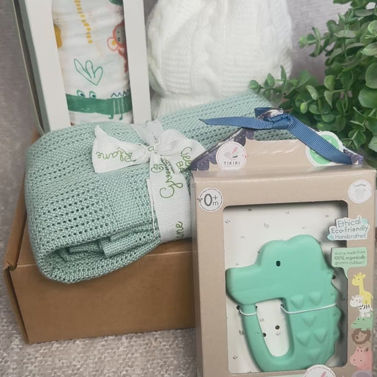 video of a baby shower gift with a bamboo baby blanket , a large swaddle, a baby hat and a crocodile natural rubber baby teether