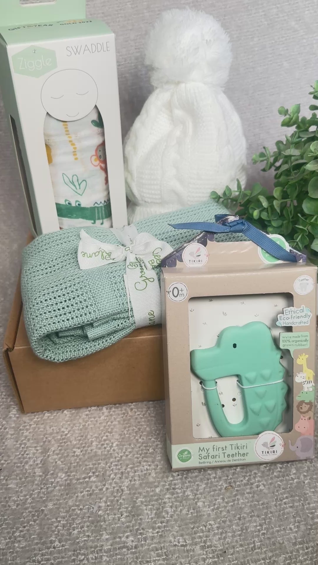 video of a baby shower gift with a bamboo baby blanket , a large swaddle, a baby hat and a crocodile natural rubber baby teether