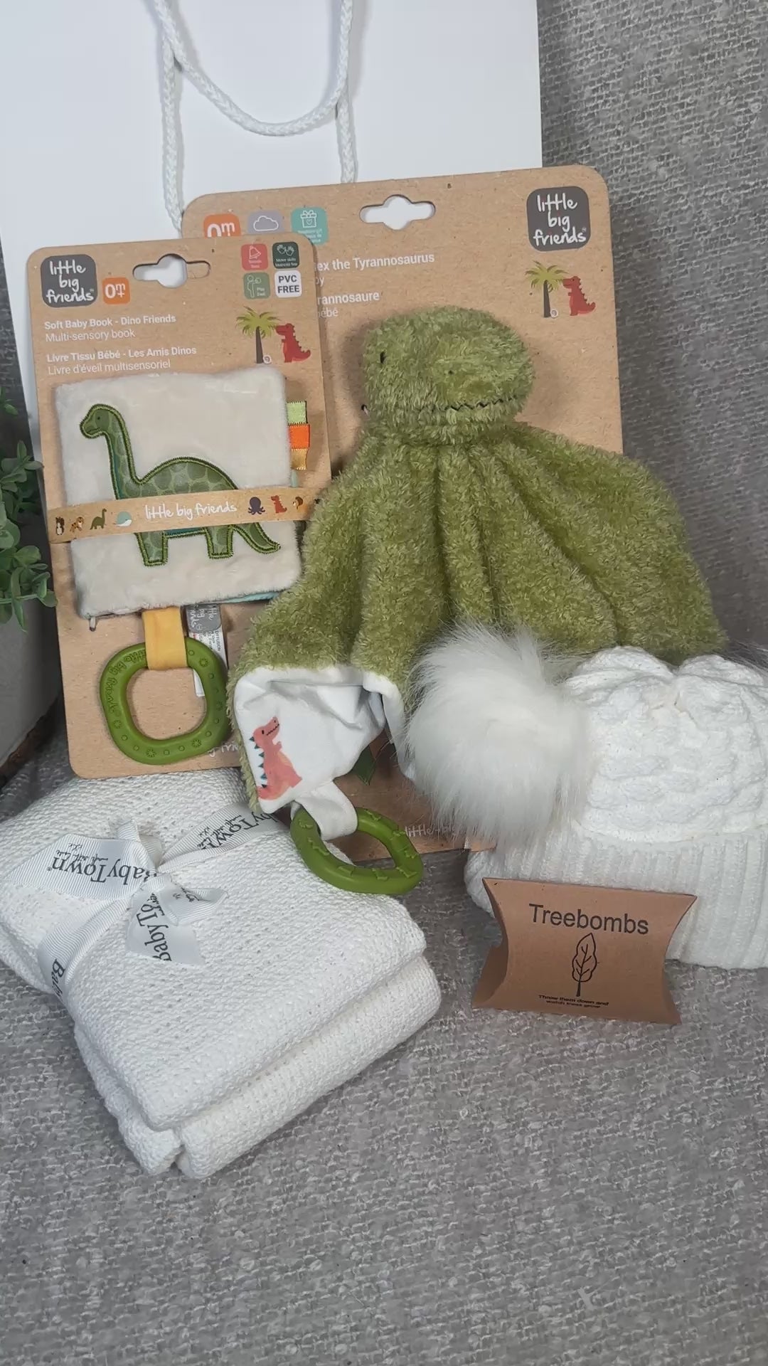 video of a dinosaur themed baby hamper with green dinosaur baby comforter and sensory baby book