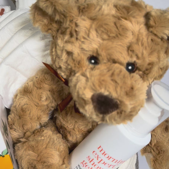 video of a baby gift basket with teddy bear, blanket, candle, shower gel.