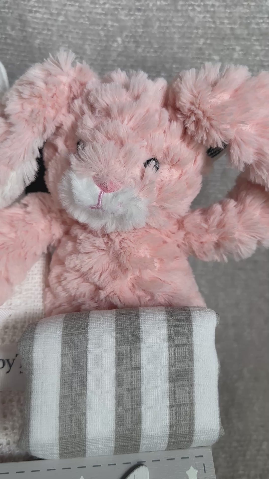 video - new baby gift box with pink bunny and white baby pompom hat.