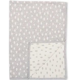 Gray and white speckled organic cotton blanket with a corner folded over