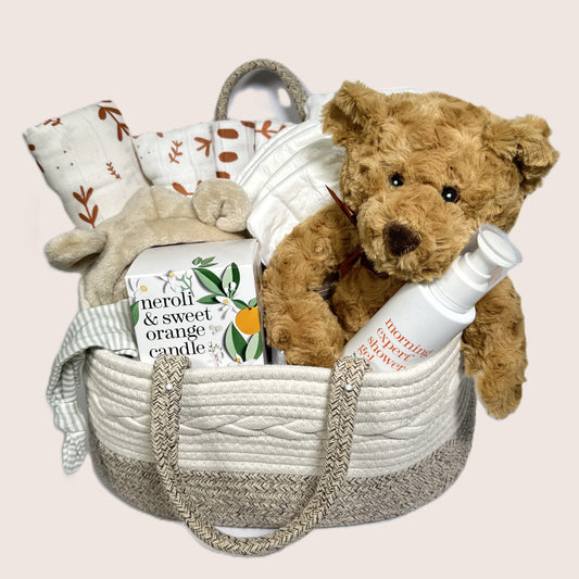 Baby gift basket with teddy bear, blanket, candle, shower gel.