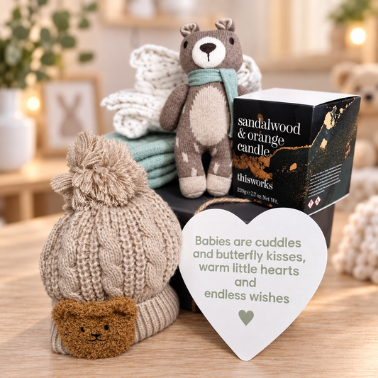 A curated neutral new baby gift hamper in a grey baby keepsake box with bamboo cellular sage green baby blanket, sandalwood and orange scented  candle, 2 baby muslins, knitted bear baby rattle, nursery plaque and pompom baby hat with bear badge