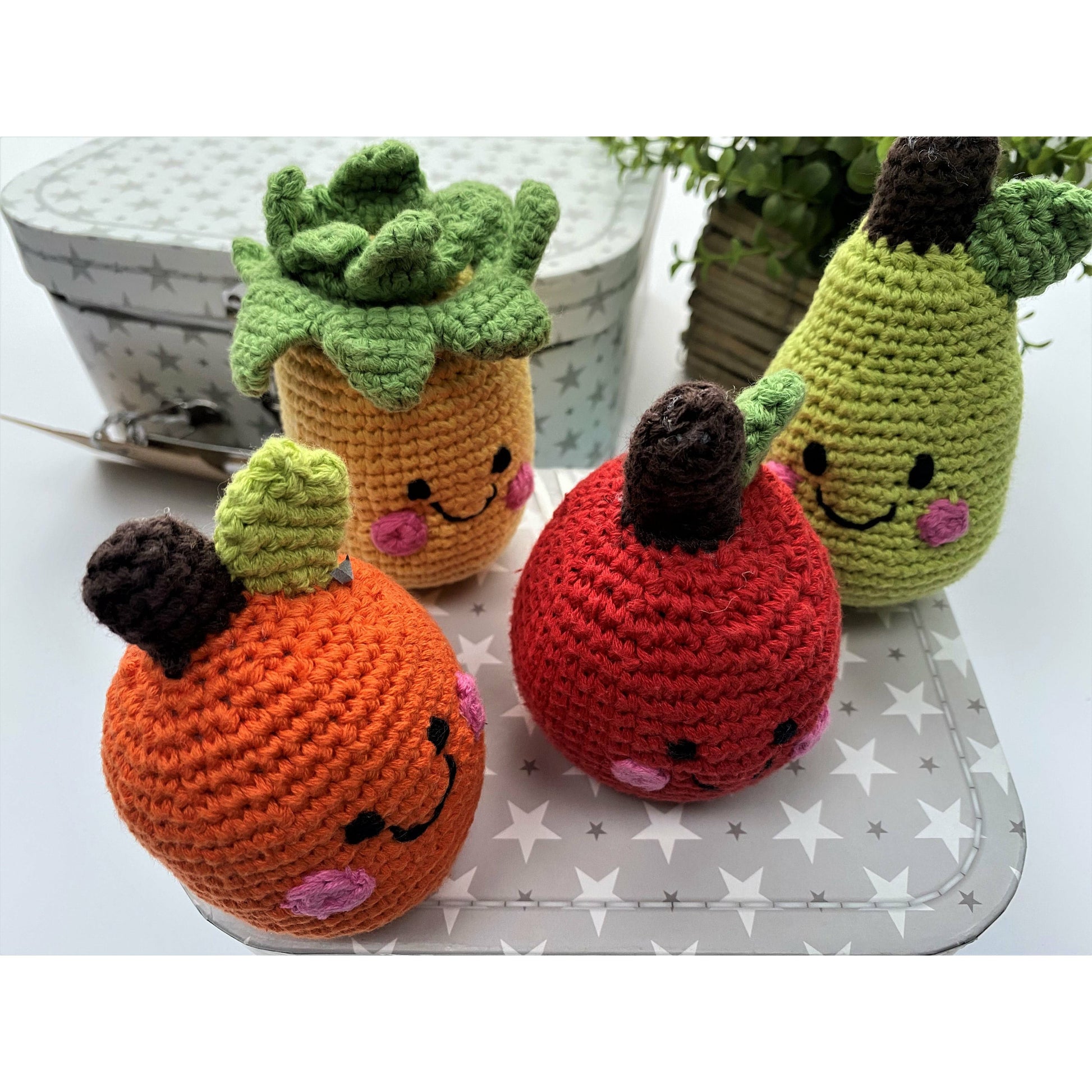 Cute chrocheted fruit baby rattles. An orange, an apple, a pear and a pineapple.