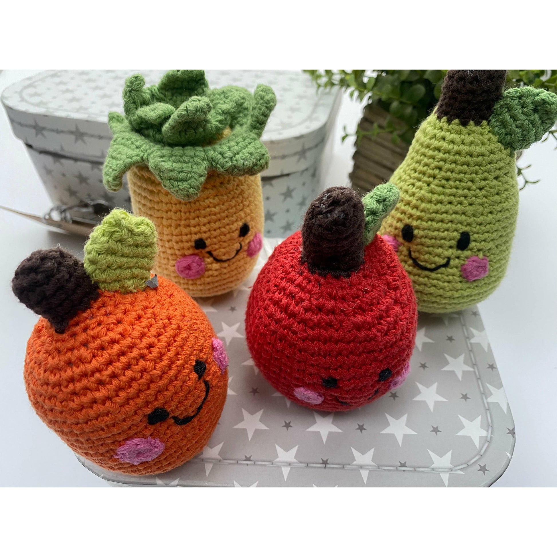 Cute chrocheted fruit baby rattles. An orange, an apple, a pear and a pineapple.