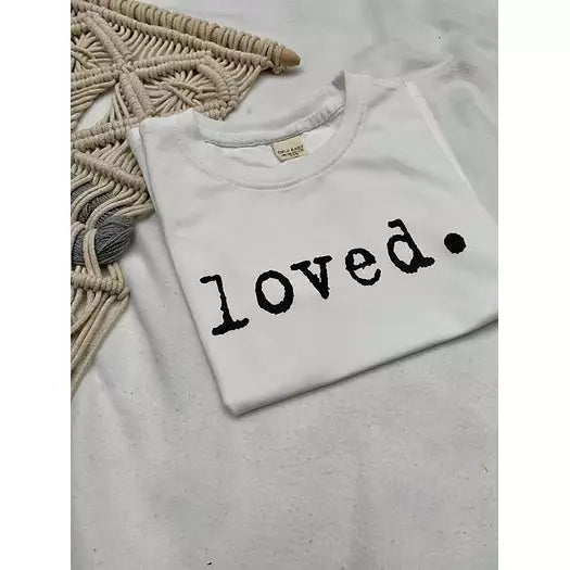 White baby t-shirt with the word loved across the front in black text.