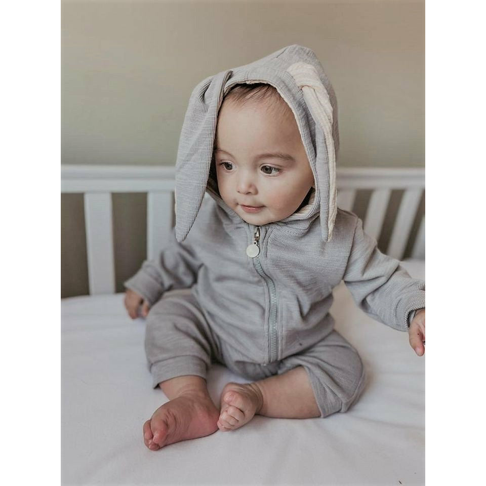 A snuggle bunny baby romper without feet, in grey with a zip up fastening and large bunny ears on the hood.